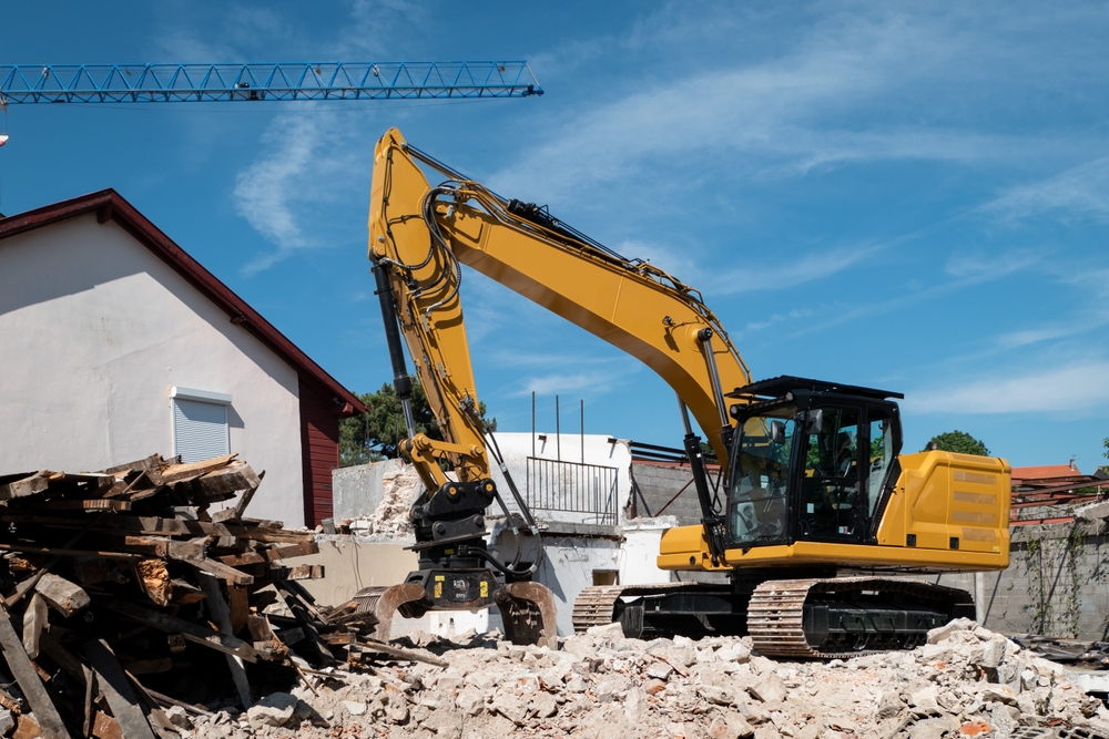 Backhoe,Demolishing,An,Old,House,For,Later,Construction,On,The